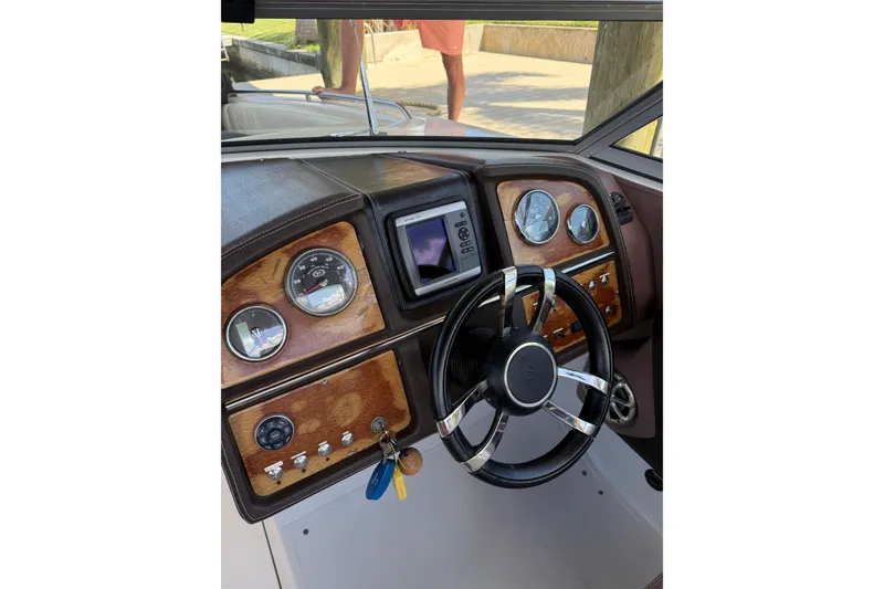 Slide: The Image of Steering wheel and dashboard of 2010 Cobalt 296 boat with wood accents and gauges. - 4