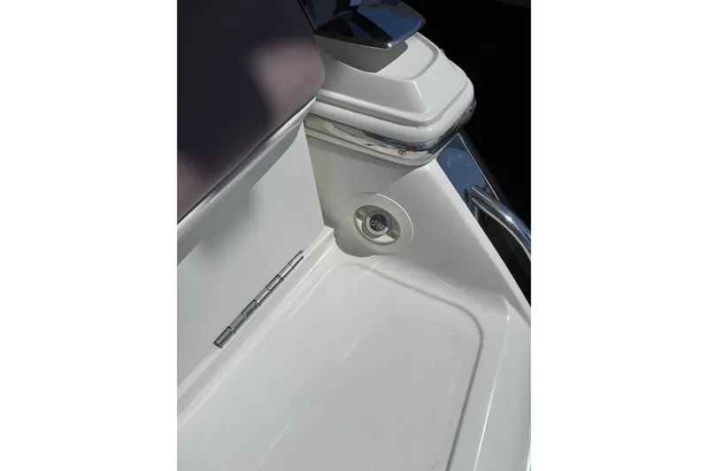 Slide: The Image of Interior detail of a 2010 Cobalt 296 boat, featuring a white seat and chrome accents. - 42