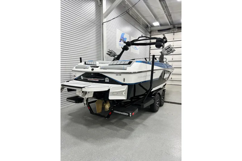 Slide: The Image of 2024 Malibu Wakesetter 24 MXZ boat in showroom, rear view, on trailer. - 2