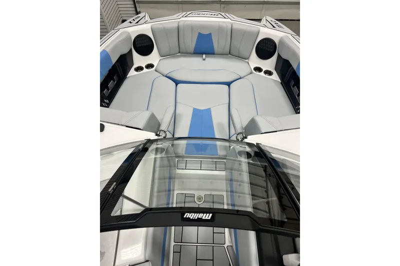 Slide: The Image of 2024 Malibu Wakesetter 24 MXZ boat interior with sleek gray and blue seating. - 6