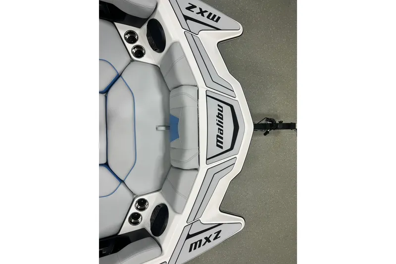 Slide: The Image of 2024 Malibu Wakesetter 24 MXZ boat interior with sleek white and blue seating. - 8