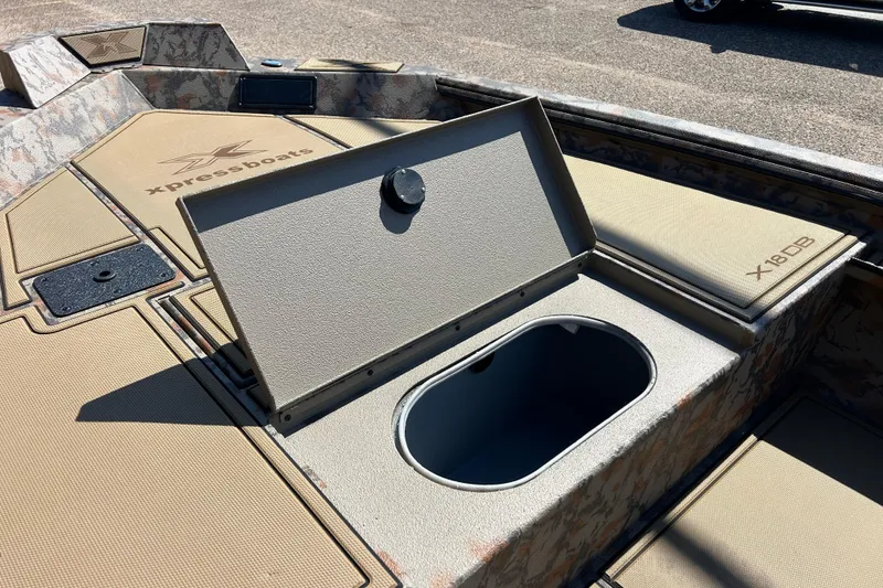 Slide: The Image of 2026 Xpress X18DB boat interior with open storage compartment and camouflage design. - 11