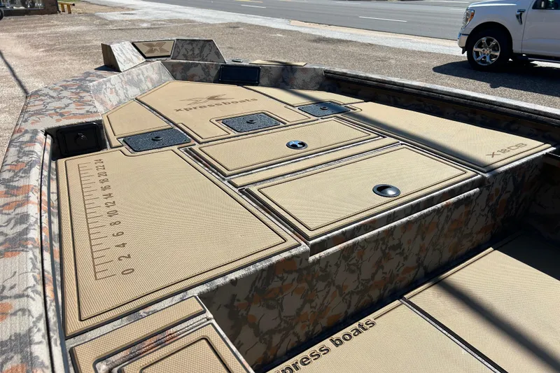 Slide: The Image of 2026 Xpress X18DB boat with camo design and storage compartments. - 4