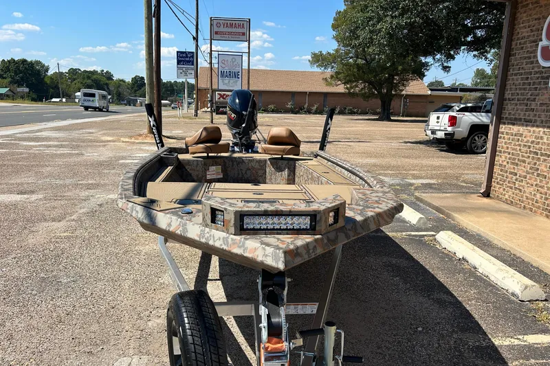 Slide: The Image of 2026 Xpress X18DB boat with camouflage design on a trailer in a parking lot. - 5