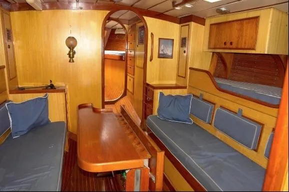 Slide: The Image of Interior of 1971 Nautor Swan 43 Sloop, featuring wooden furnishings and blue cushions. - 3