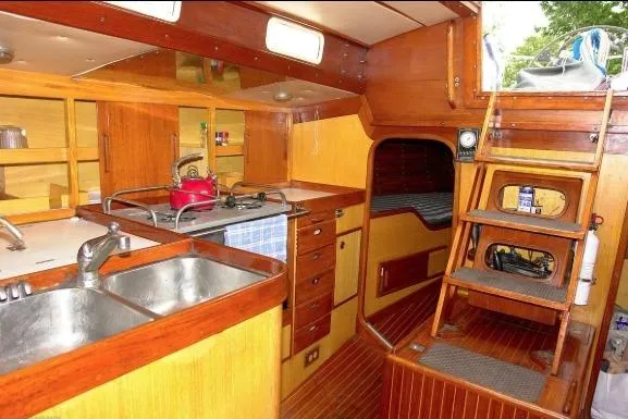 Slide: The Image of Interior of 1971 Nautor Swan 43 Sloop, featuring wooden cabinetry and compact kitchen area. - 7