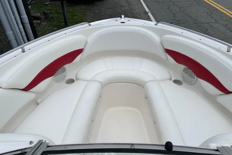 Slide: The Image of 2000 Chaparral 216 SSi boat interior with white and red seating, showing spacious bow area. - 26