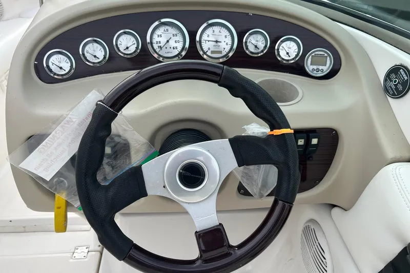 Slide: The Image of 2000 Chaparral 216 SSi boat interior with white and red seating, dashboard, and steering wheel. - 3