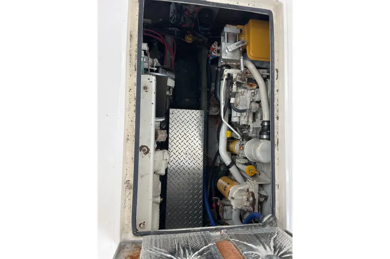 Slide: The Image of Engine compartment of a 1999 Albemarle 30 boat, showcasing mechanical components and piping. - 16