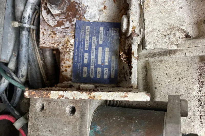Slide: The Image of Rusty engine component with a blue identification plate on a 1999 Albemarle 30 boat. - 31