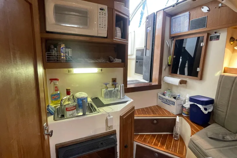 Slide: The Image of Interior of 1999 Albemarle 30 boat with kitchenette and wooden stairs. - 7