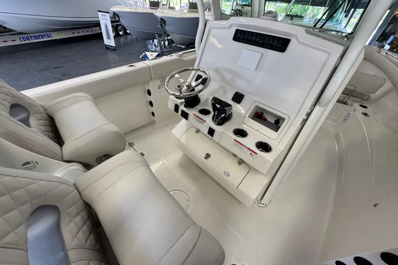 Slide: The Image of 2026 Sailfish 272 CC boat interior with steering console and cushioned seating. - 2