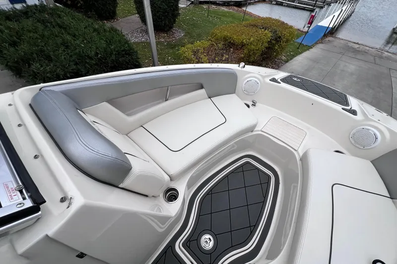 Slide: The Image of 2010 Sea Ray 220 Sundeck boat interior with cushioned seating and sleek design. - 24