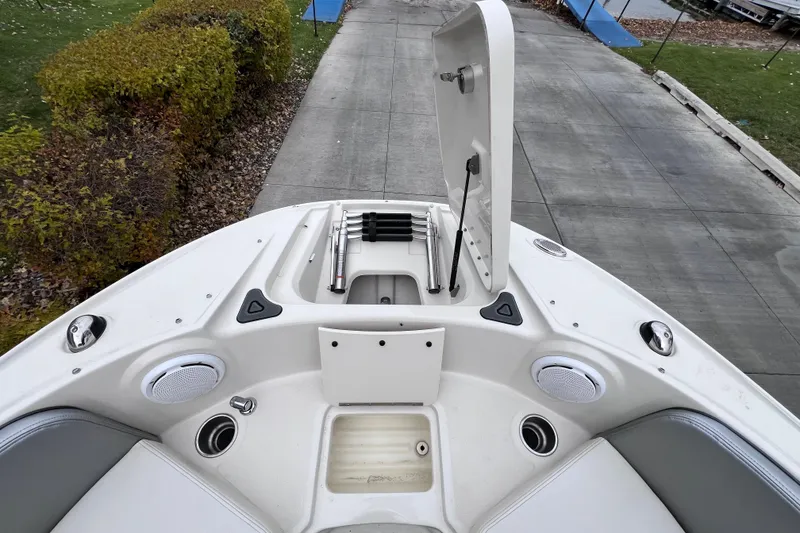 Slide: The Image of 2010 Sea Ray 220 Sundeck bow with open storage compartment and speakers. - 25