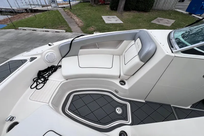 Slide: The Image of 2010 Sea Ray 220 Sundeck interior with white seating and black flooring. - 26