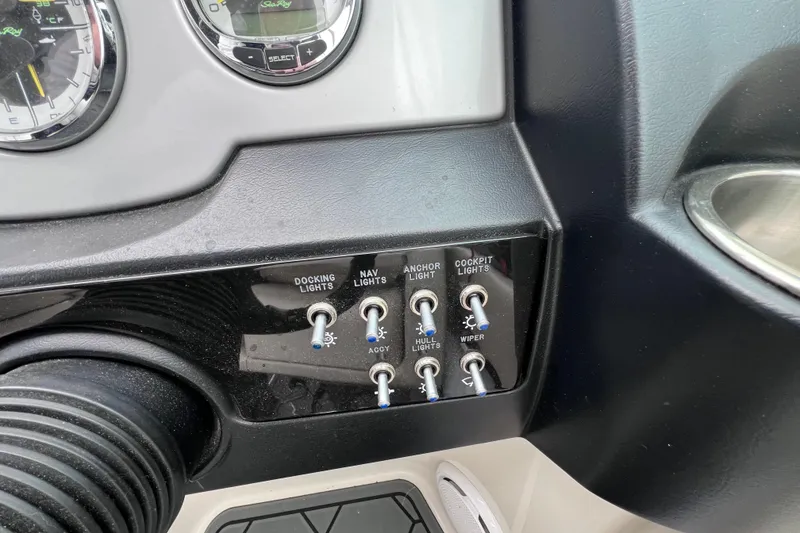 Slide: The Image of Control panel of a 2010 Sea Ray 220 Sundeck boat with various light switches. - 33
