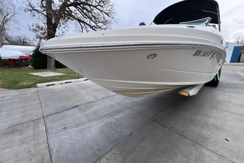 Slide: The Image of 2010 Sea Ray 220 Sundeck boat on trailer, parked on concrete driveway. - 4