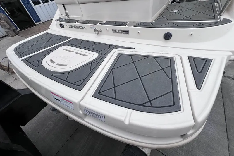 Slide: The Image of Rear view of 2010 Sea Ray 220 Sundeck boat with swim platform and textured mats. - 9