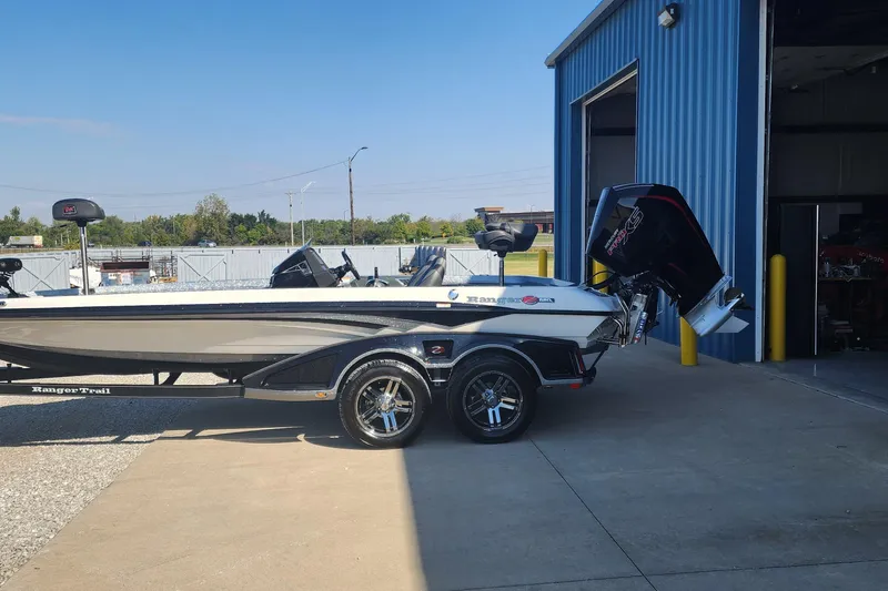 Slide: The Image of 2020 Ranger Z520L boat on trailer outside blue building under clear sky. - 1