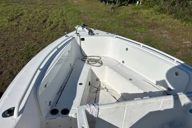 Slide: The Image of 2019 Everglades 290 Center Console boat on grassy terrain, showing spacious deck layout. - 7