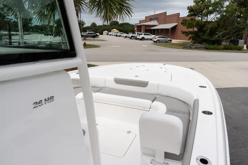 Slide: The Image of 2026 Caymas 26 HB boat with sleek design, parked near a building and palm trees. - 13