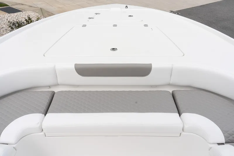 Slide: The Image of 2026 Caymas 26 HB boat bow with cushioned seating and storage hatch. - 16