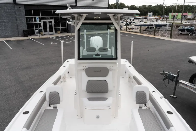 Slide: The Image of 2026 Caymas 26 HB boat with sleek design and spacious seating at a dealership. - 17
