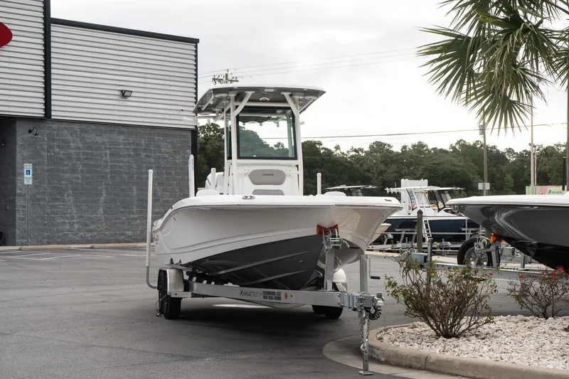 Slide: The Image of 2026 Caymas 26 HB boat on trailer in parking lot, near palm tree. - 3