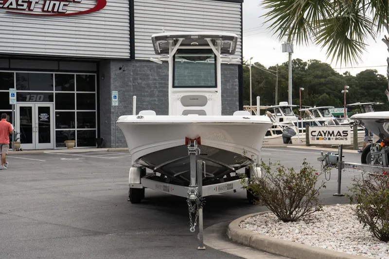 Slide: The Image of 2026 Caymas 26 HB boat on trailer outside dealership, surrounded by other boats and palm trees. - 4