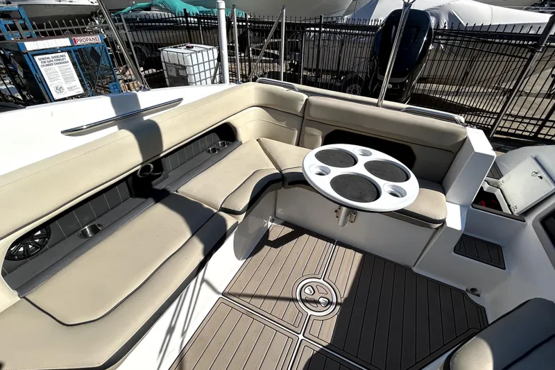Slide: The Image of 2018 Rinker Q5 OB boat interior with beige seating and round table. - 10