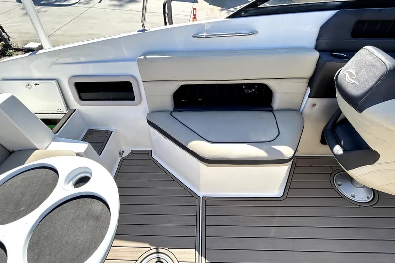 Slide: The Image of 2018 Rinker Q5 OB boat interior with seating and cup holders on deck. - 16