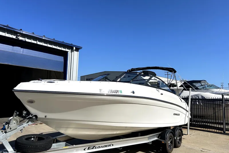 Slide: The Image of 2018 Rinker Q5 OB boat on trailer, parked outdoors under clear blue sky. - 5