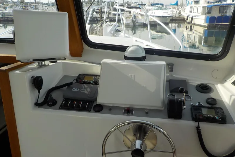 Slide: The Image of 2008 Calvin Beal Downeast boat helm with navigation equipment and marina view. - 14