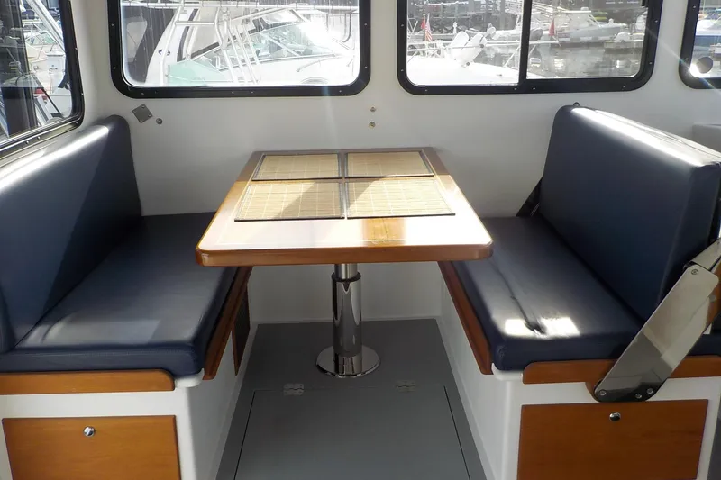 Slide: The Image of Interior of a 2008 Calvin Beal Downeast boat with a cozy dining area. - 27