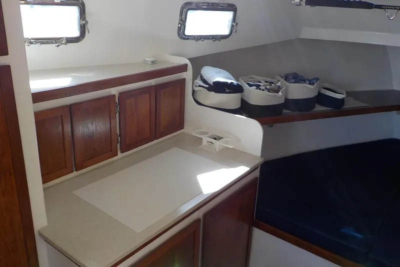 Slide: The Image of 2008 Calvin Beal Downeast boat interior with wooden cabinets and cozy sleeping area. - 31