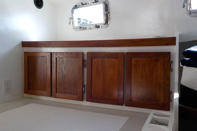 Slide: The Image of 2008 Calvin Beal Downeast boat interior with wooden cabinets and porthole window. - 33