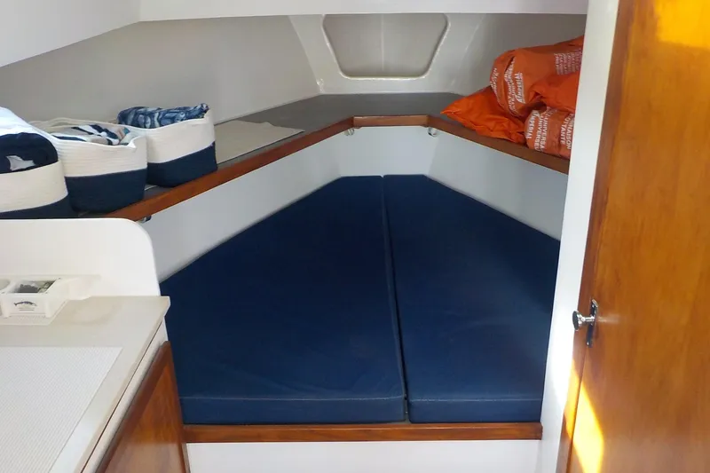 Slide: The Image of 2008 Calvin Beal Downeast boat cabin with blue cushions and storage baskets. - 35
