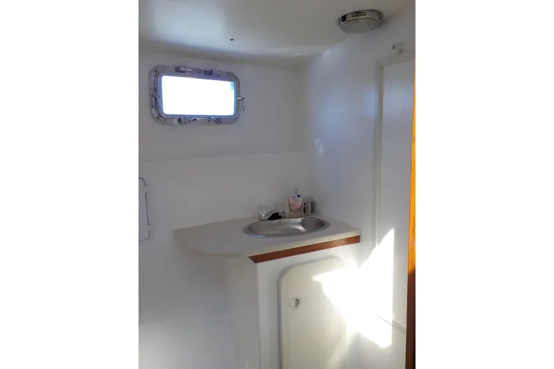 Slide: The Image of 2008 Calvin Beal Downeast boat interior with sink and porthole window. - 37