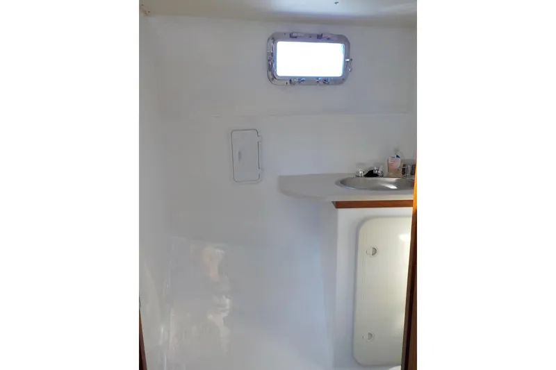 Slide: The Image of 2008 Calvin Beal Downeast boat interior bathroom with sink and porthole window. - 38
