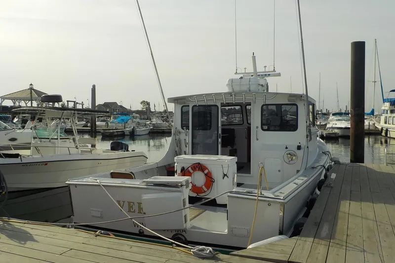 Slide: The Image of 2008 Calvin Beal Downeast boat docked at a marina, surrounded by other vessels. - 4