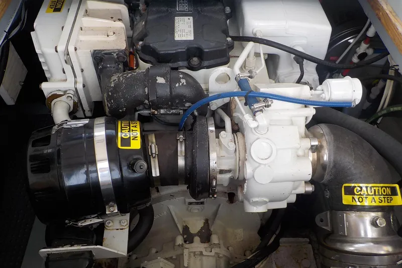 Slide: The Image of Engine compartment of a 2008 Calvin Beal Downeast boat, featuring mechanical components and caution labels. - 45