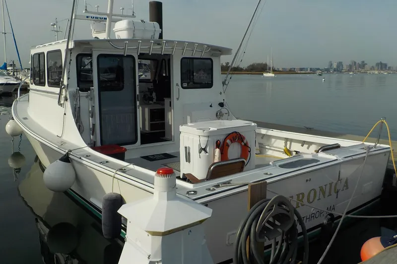 Slide: The Image of 2008 Calvin Beal Downeast boat docked in a marina with city skyline in background. - 6