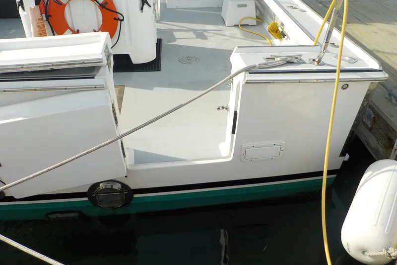 Slide: The Image of 2008 Calvin Beal Downeast boat docked, featuring open deck and safety equipment. - 9