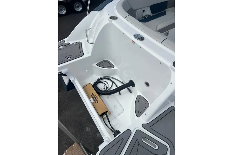 Slide: The Image of 2026 Hurricane SunDeck 2400 OB boat interior with storage compartment and accessories. - 2