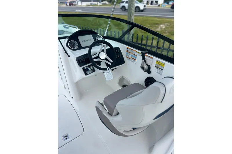 Slide: The Image of 2026 Hurricane SunDeck 2400 OB boat cockpit with steering wheel and Garmin display. - 3