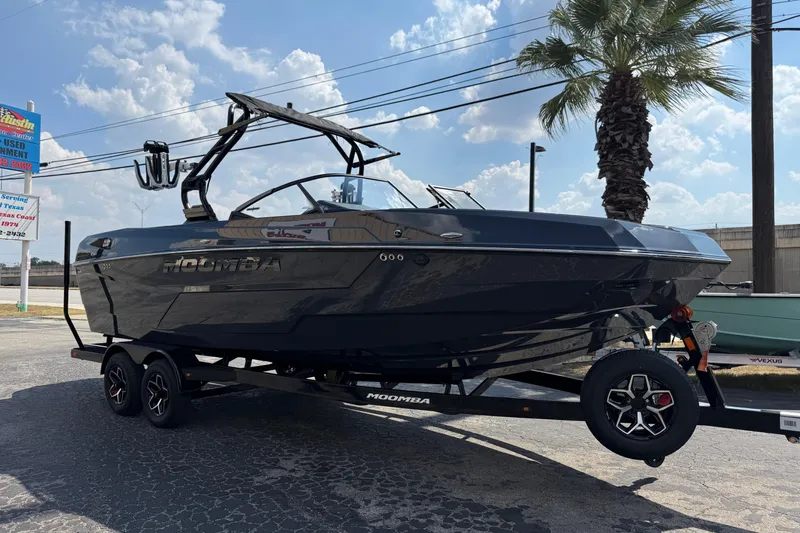The Image of 2026 Moomba Tykon boat on trailer, parked outdoors under a sunny sky. - 0