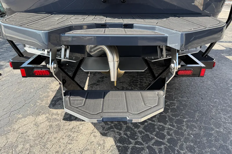 Slide: The Image of 2026 Moomba Tykon boat rear view with swim platform and exhaust detail. - 11