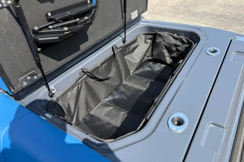 Slide: The Image of Open storage compartment in 2026 Moomba Tykon boat, featuring black interior lining. - 16
