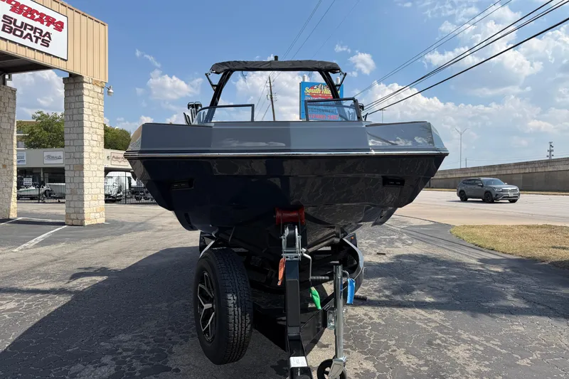 Slide: The Image of 2026 Moomba Tykon boat on trailer at dealership, sunny day. - 2