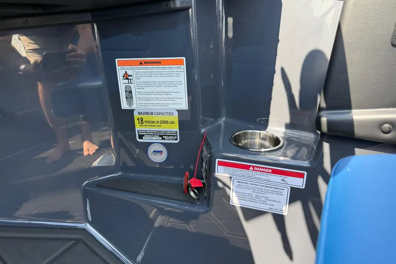 Slide: The Image of 2026 Moomba Tykon boat interior with warning labels and cup holder. - 29